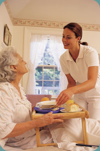A caregiver serving a meal to a client at home